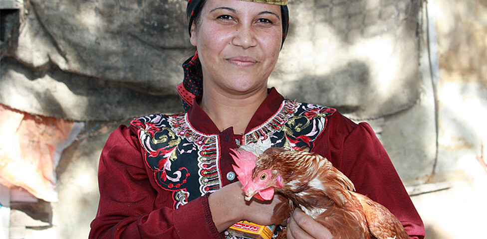 Eine ägyptische Frau mit einem Huhn in der Hand.