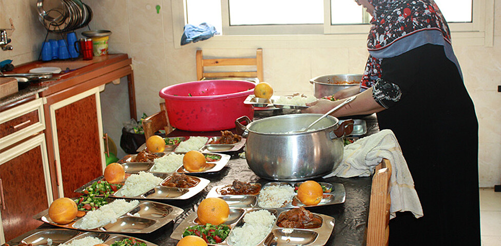 Eine Frau bereitet das Essen für die Kinder zu.