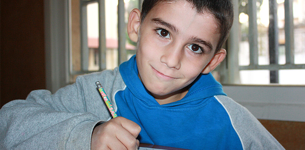 Ein Junge beim Schreiben im Klassenraum der Schule in Broumana, Libanon