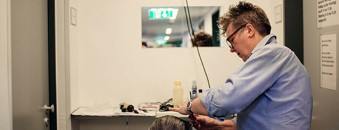Freiwillige Mitarbeiterin beim Haare schneiden